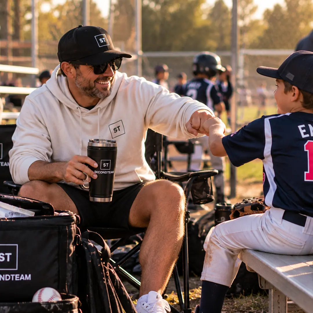 Parent and player fist bumping over a SECONDTEAM cooler