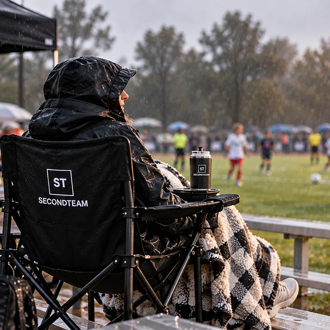 Parent watching from a SECONDTEAM chair in the rain